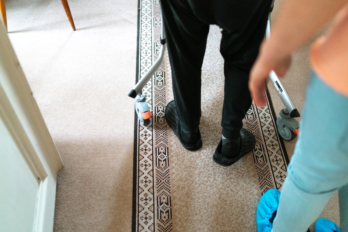 A caregiver helping a client walk safely