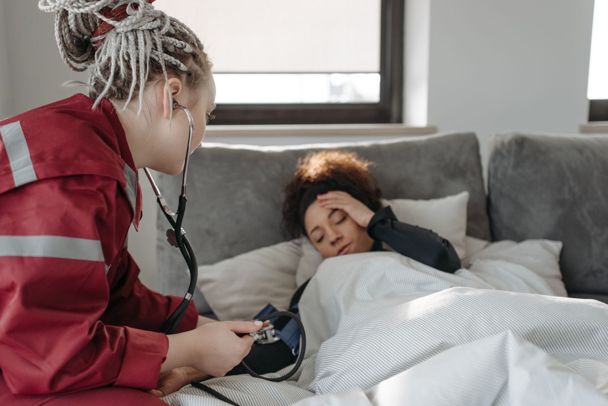 A home health worker checking on a recovering patient